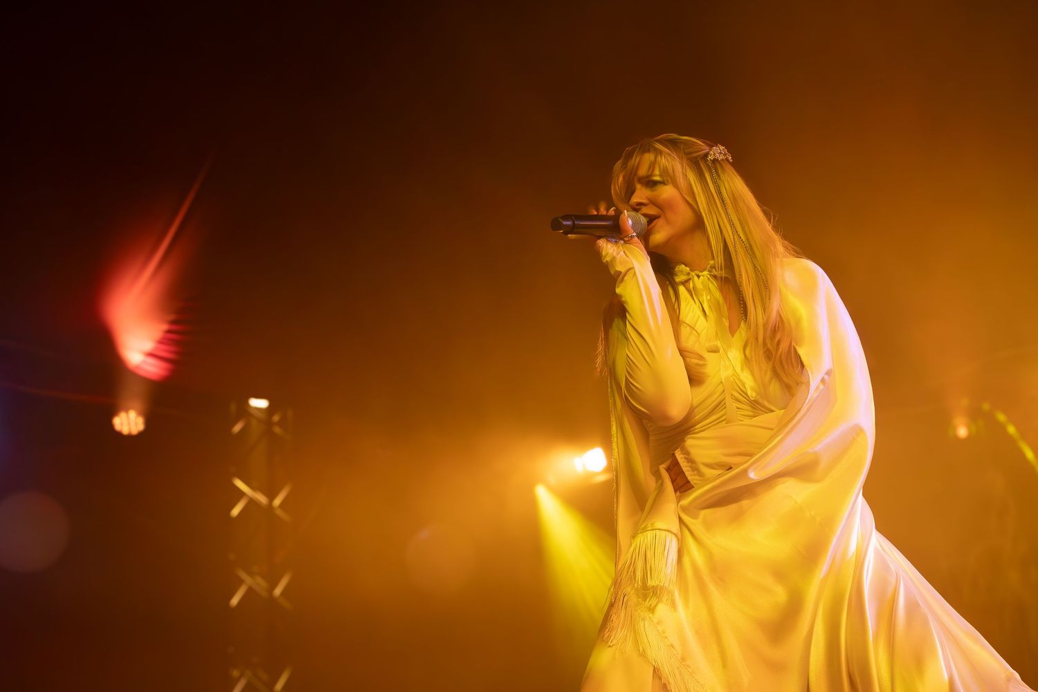 Concert performance bathed in warm amber lighting creates a dramatic atmospheric mood.