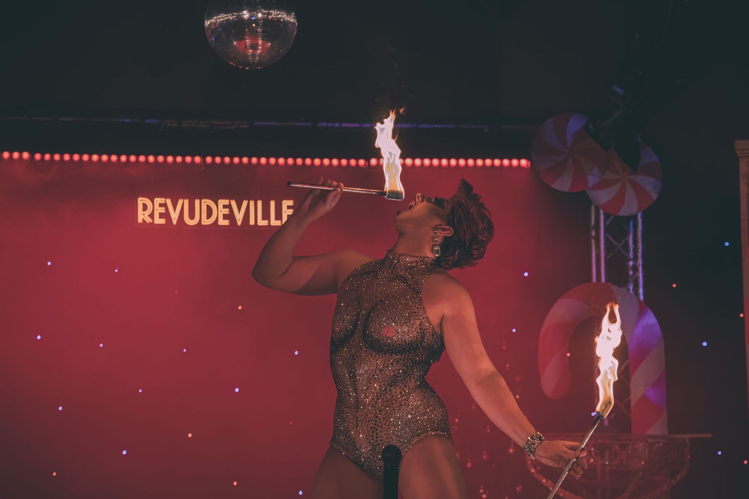 Theatrical performance with red lighting and dramatic stage effects.