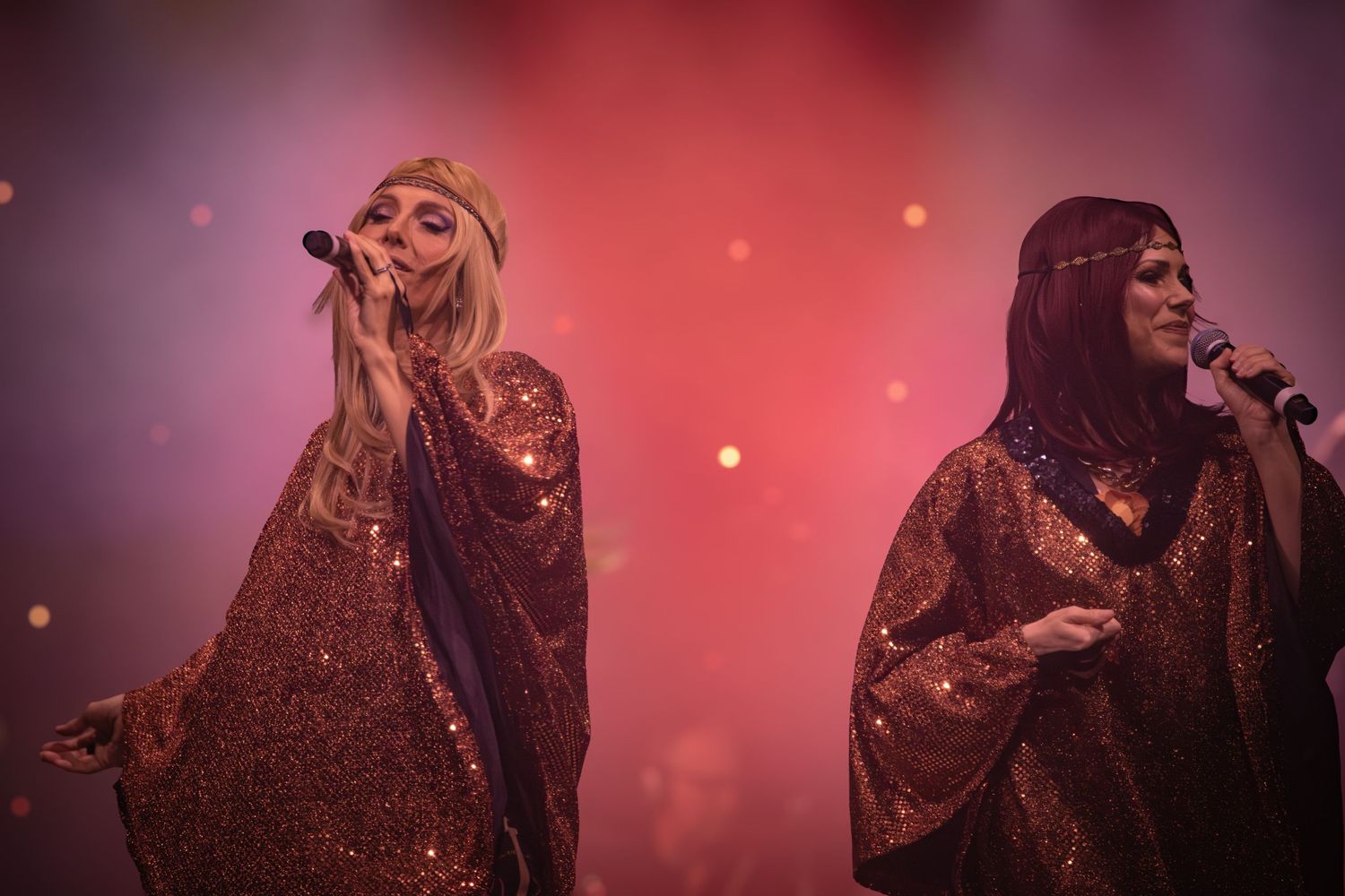 Performers on stage with dramatic red lighting and atmospheric smoke effects.