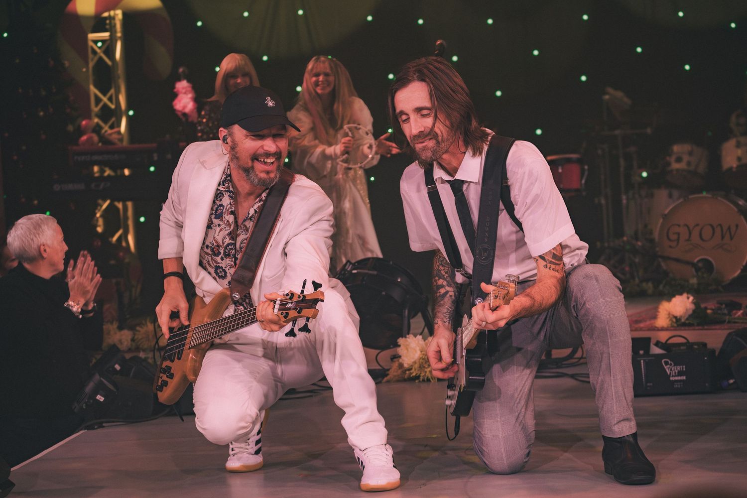 Musicians performing on stage with vintage-style lighting and intimate setting.