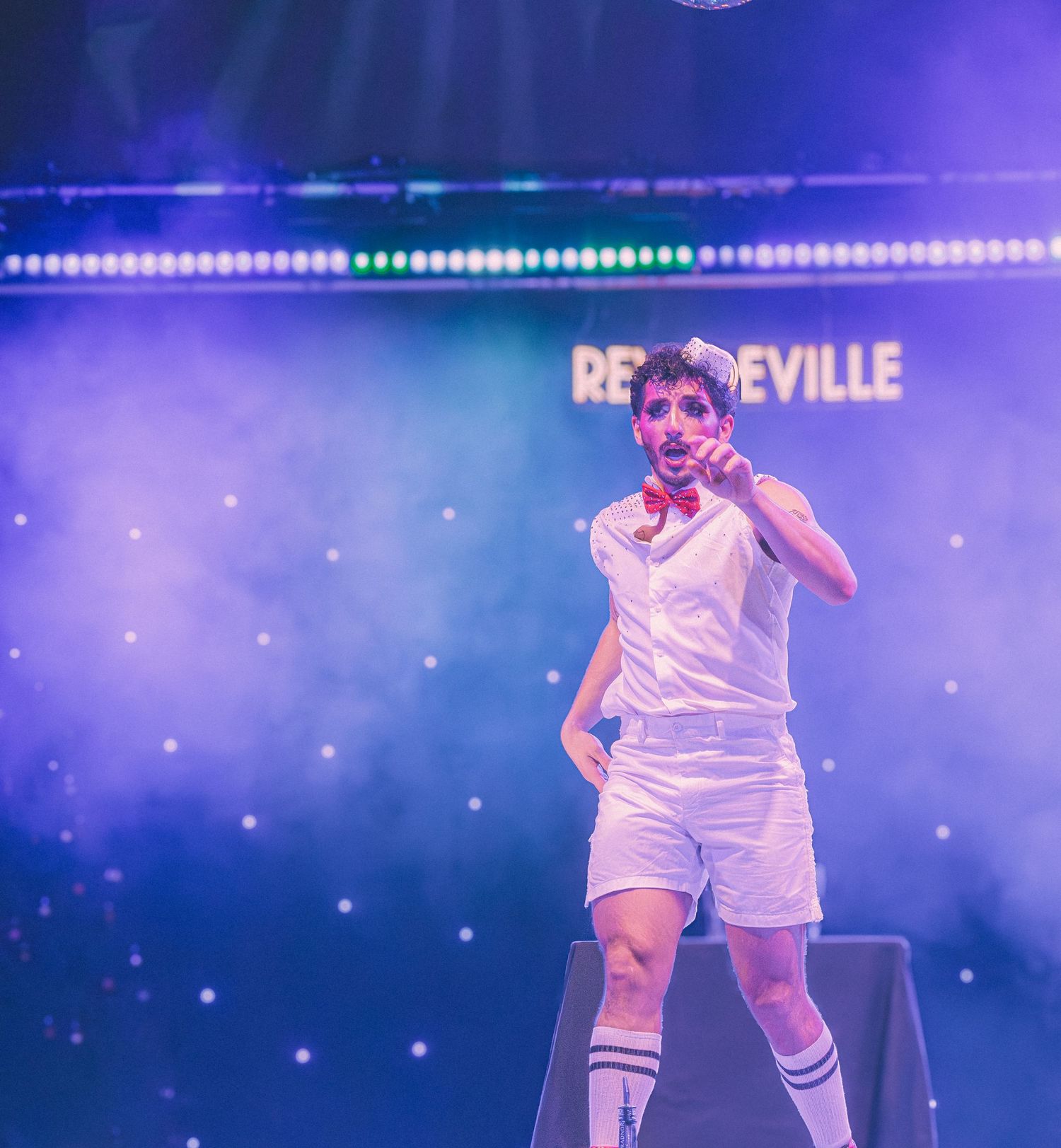 Roller skating performance on illuminated stage with fog effects and blue lighting.