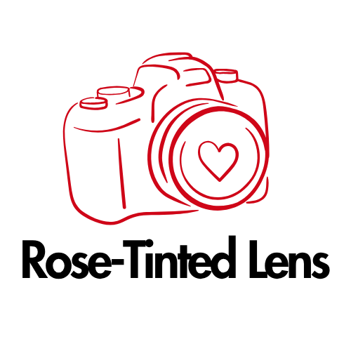 Red outline logo of a DSLR camera with a heart on the lens above the text Rose-Tinted Lens on white background.