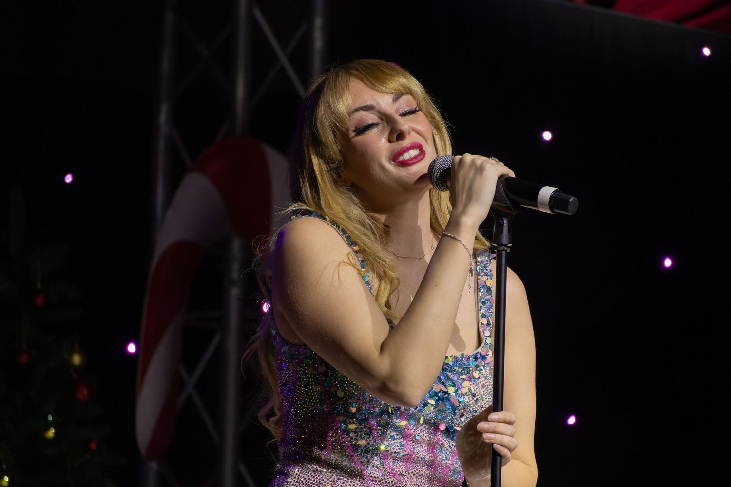 Energetic stage performance with holiday decorations visible in background.