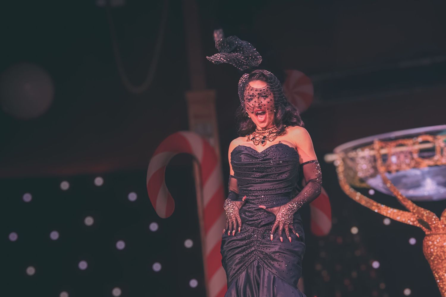 Burlesque show featuring dramatic dance moves with vintage-style stage props and lighting.