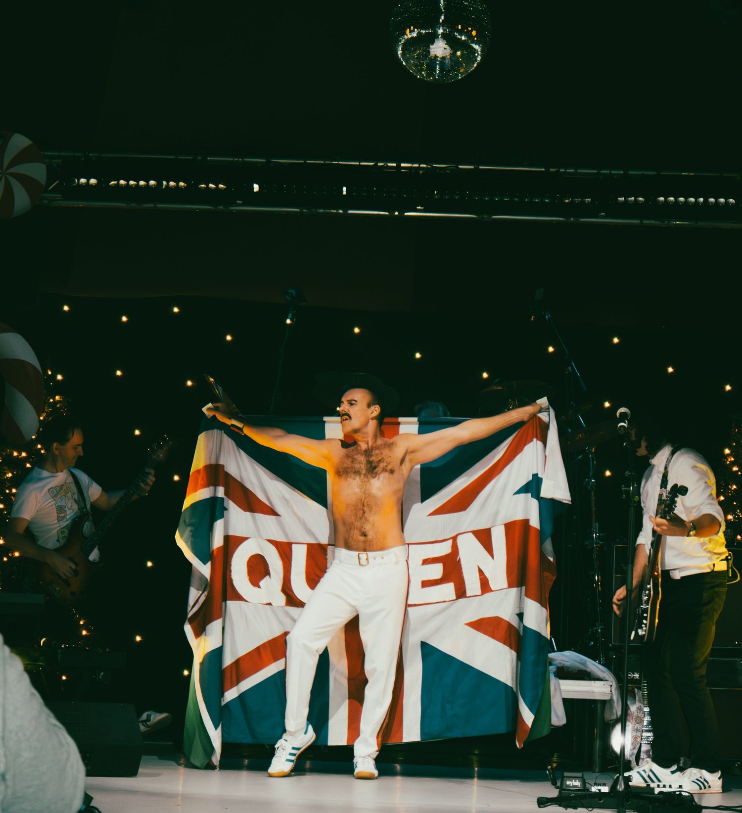 Stage performance featuring Union Jack flag display and dramatic lighting effects.