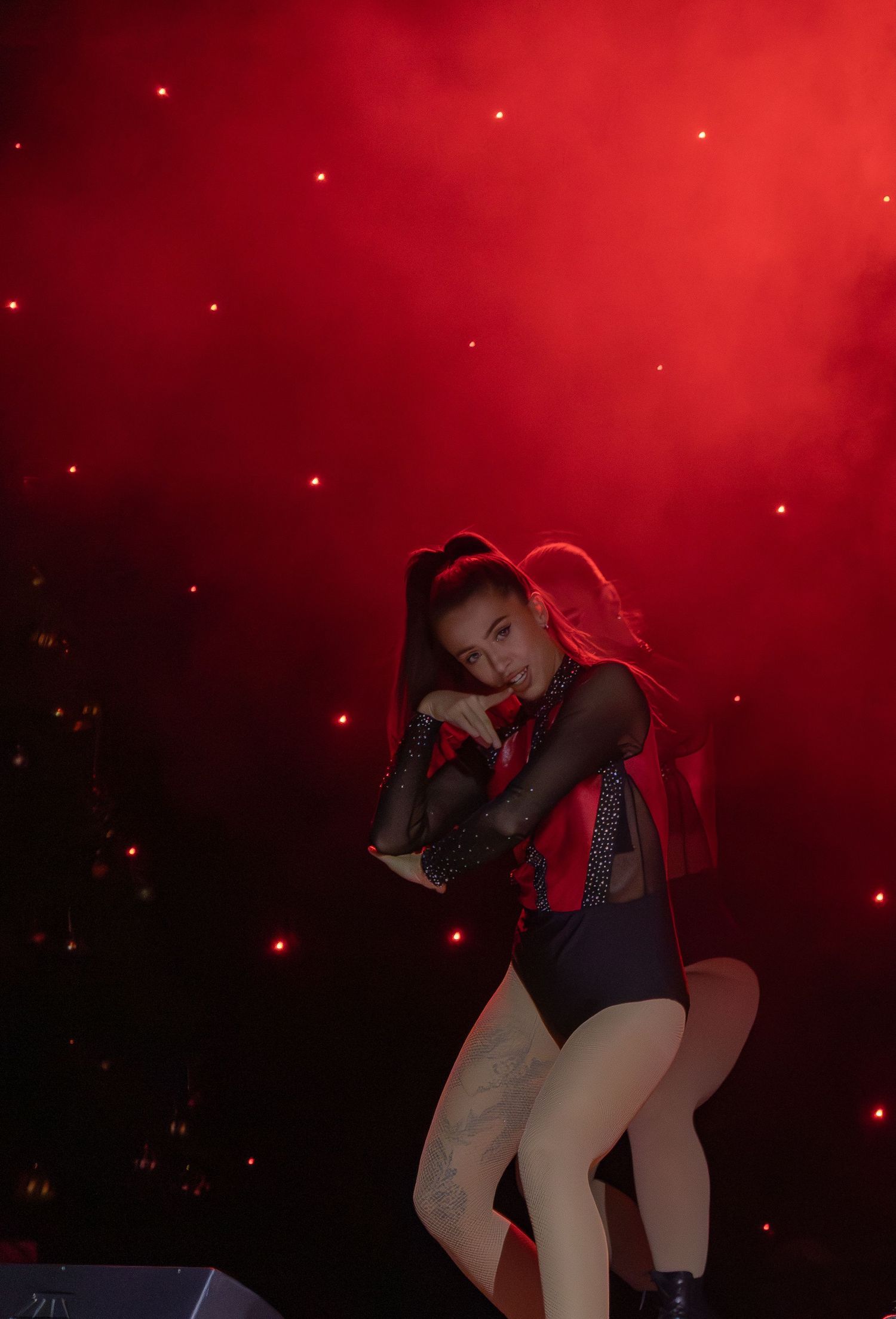 A dramatic dance performance with red lighting effects and twinkling stars in the background.