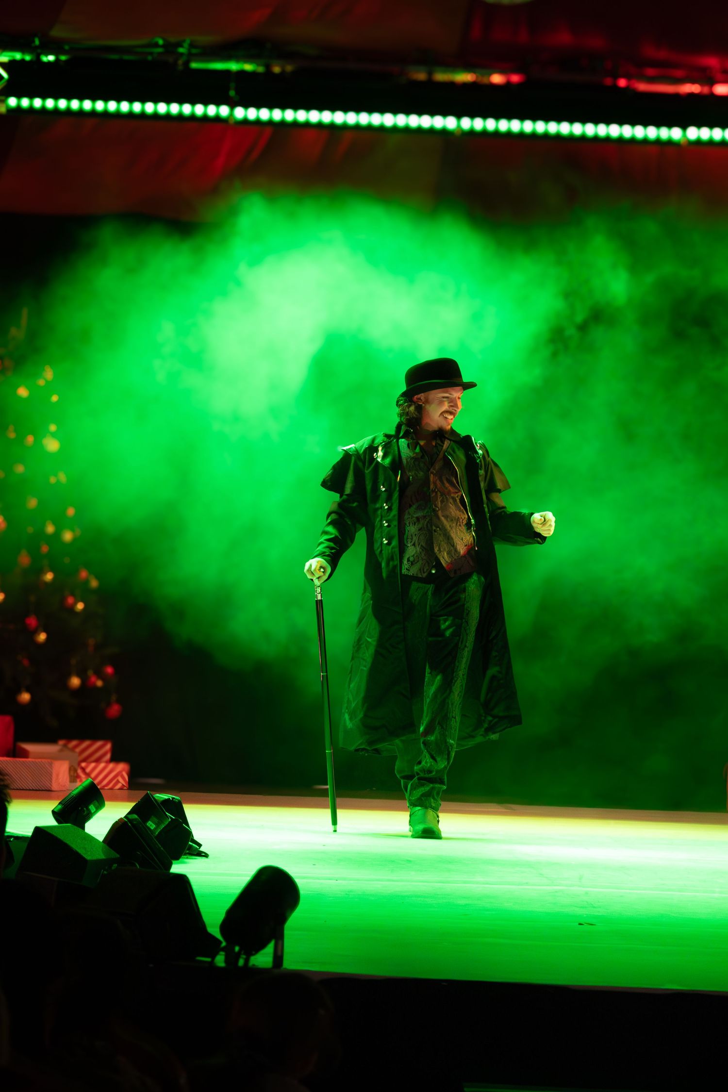 Solo performer on stage surrounded by atmospheric green smoke effects.