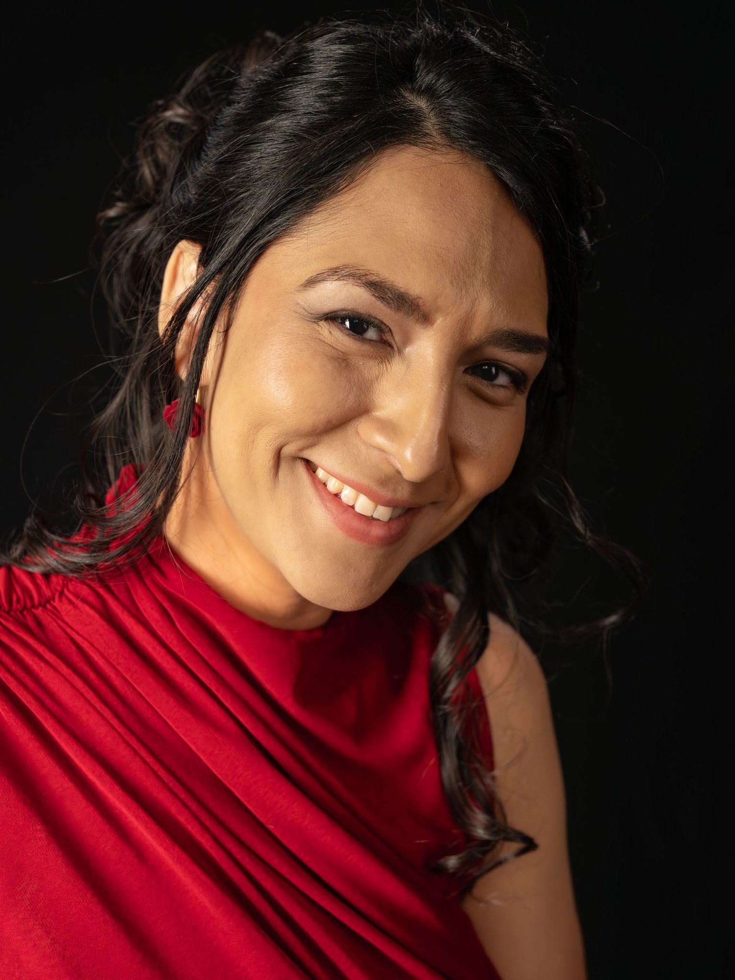 Portrait series of woman in red turtleneck against black background showing different expressions.