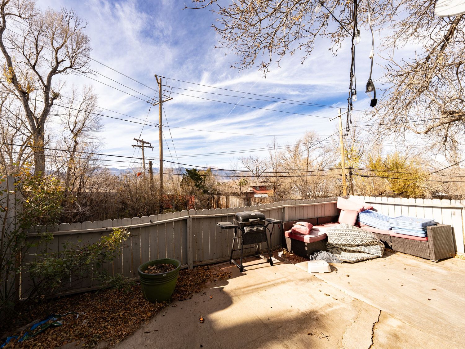 Exterior panoramic view of residential property with bare trees and blue winter sky.