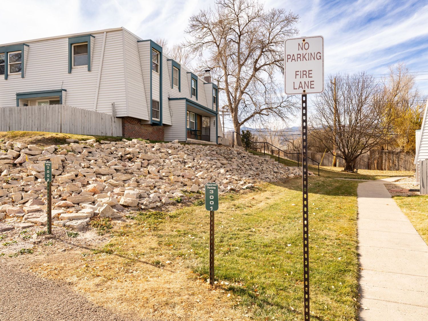Sidewalk path with green lampposts leading to residential buildings on a sunny day.