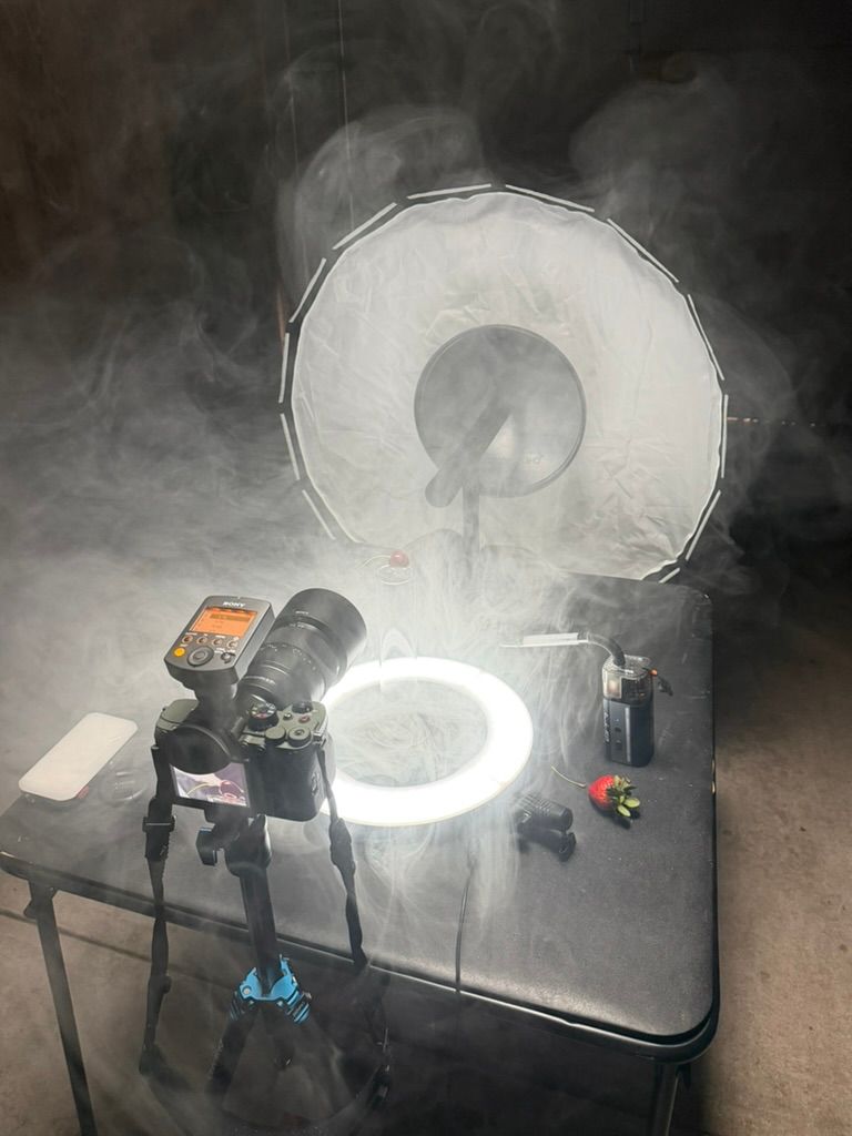 Photography setup with ring light and softbox creating atmospheric smoke effects.