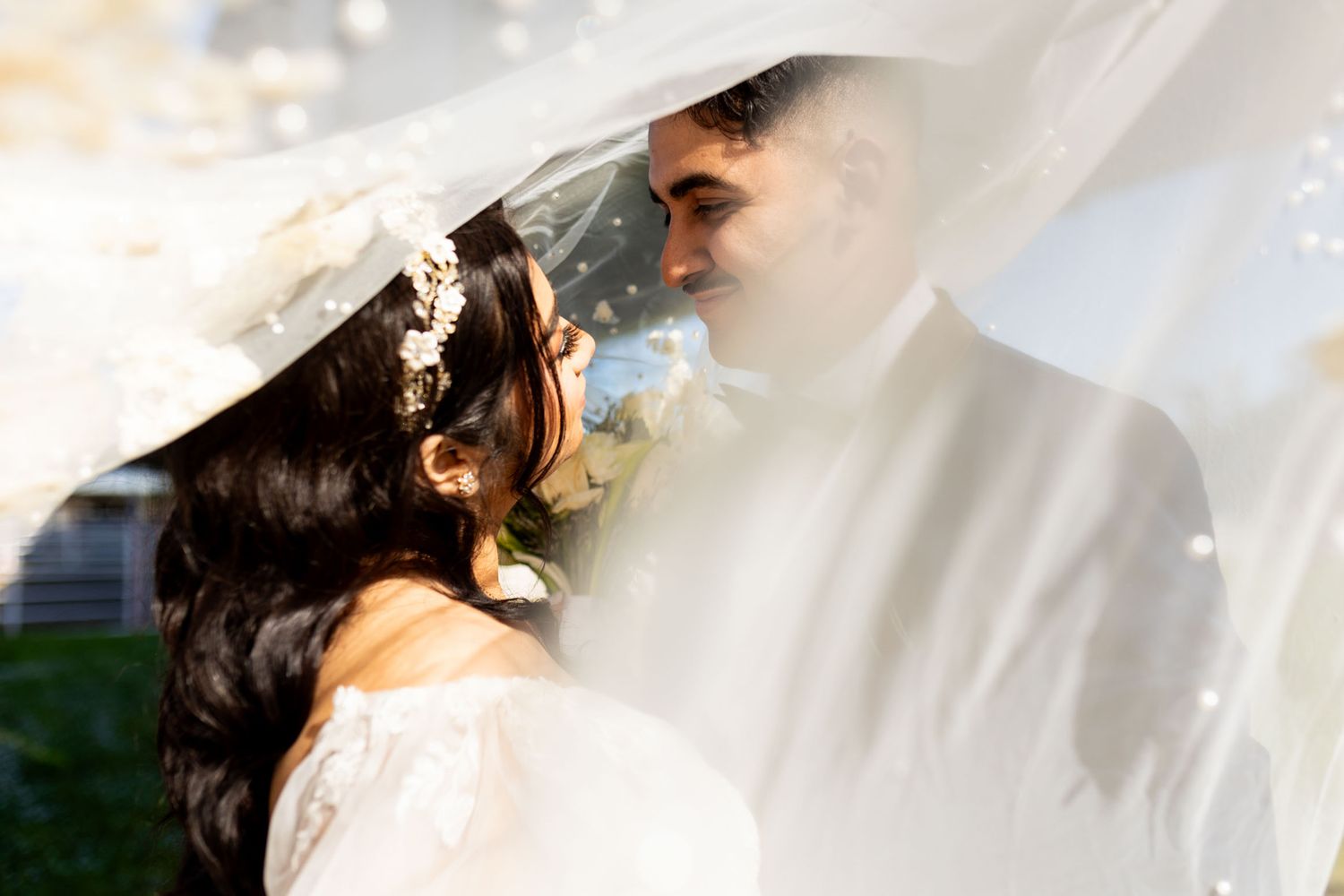 A couple embraces in a romantic moment during their wedding ceremony, surrounded by soft lighting and floral decor.