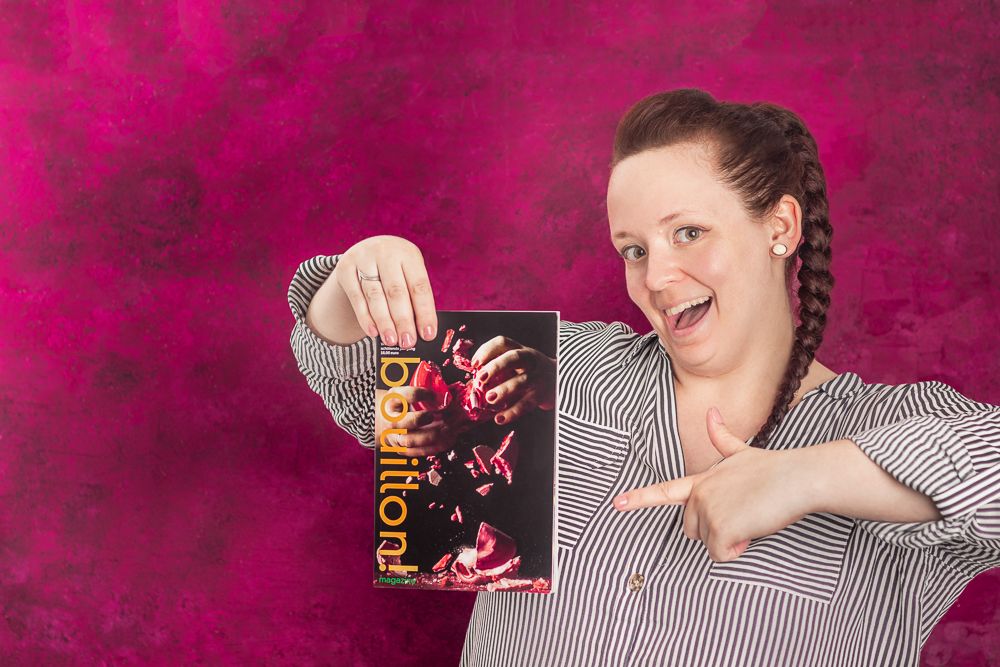 Reka Peurala playfully presents a food photography publication against a magenta backdrop. Photo by © Reka Peurala, Three Pod Studio