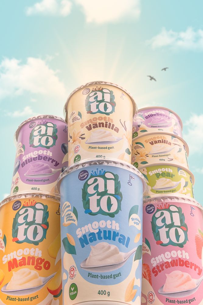 Colourful yoghurt packs styled against a bright sky with clouds. Photo by © Reka Peurala – Three Pod Studio