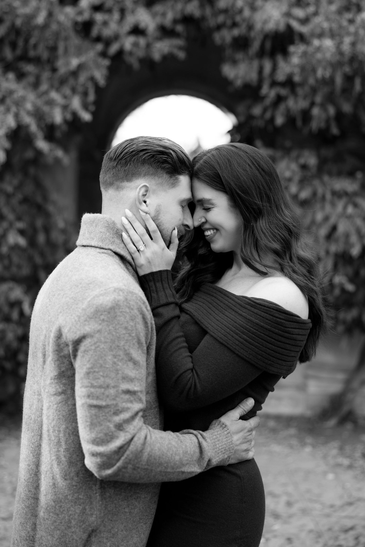 A romantic black and white portrait of a couple embracing under a garden archway at the Goerge Eastman House engagement photos in Rochester.
