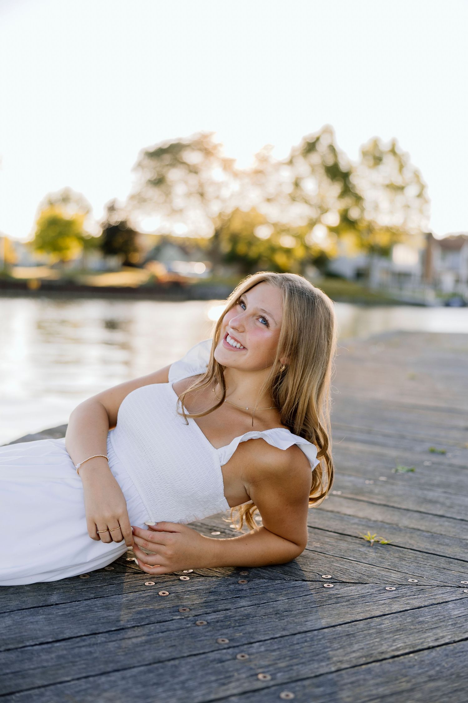 Artistic portrait on wooden deck during golden hour sunset at Canandaigua Lake House for Rochester NY senior portaits.