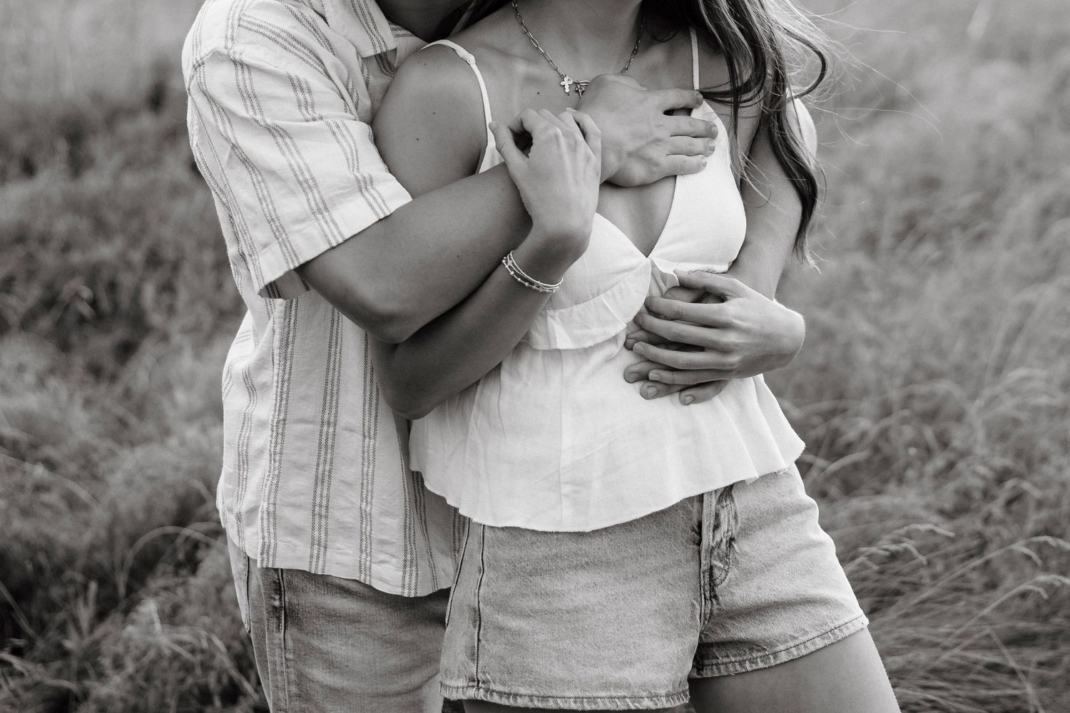 A romantic couple embraces in a black and white outdoor photoshoot in field in Hilton, NY.