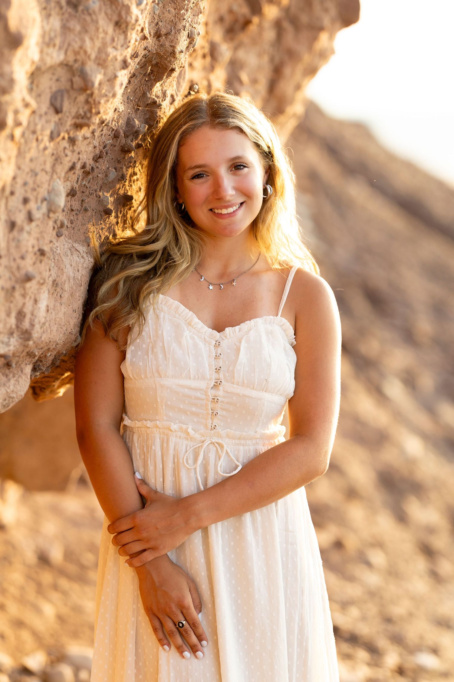 Ethereal senior portrait session against rocky cliffs or Chimney Bluffs during golden hour with soft natural lighting. Rochester, NY.