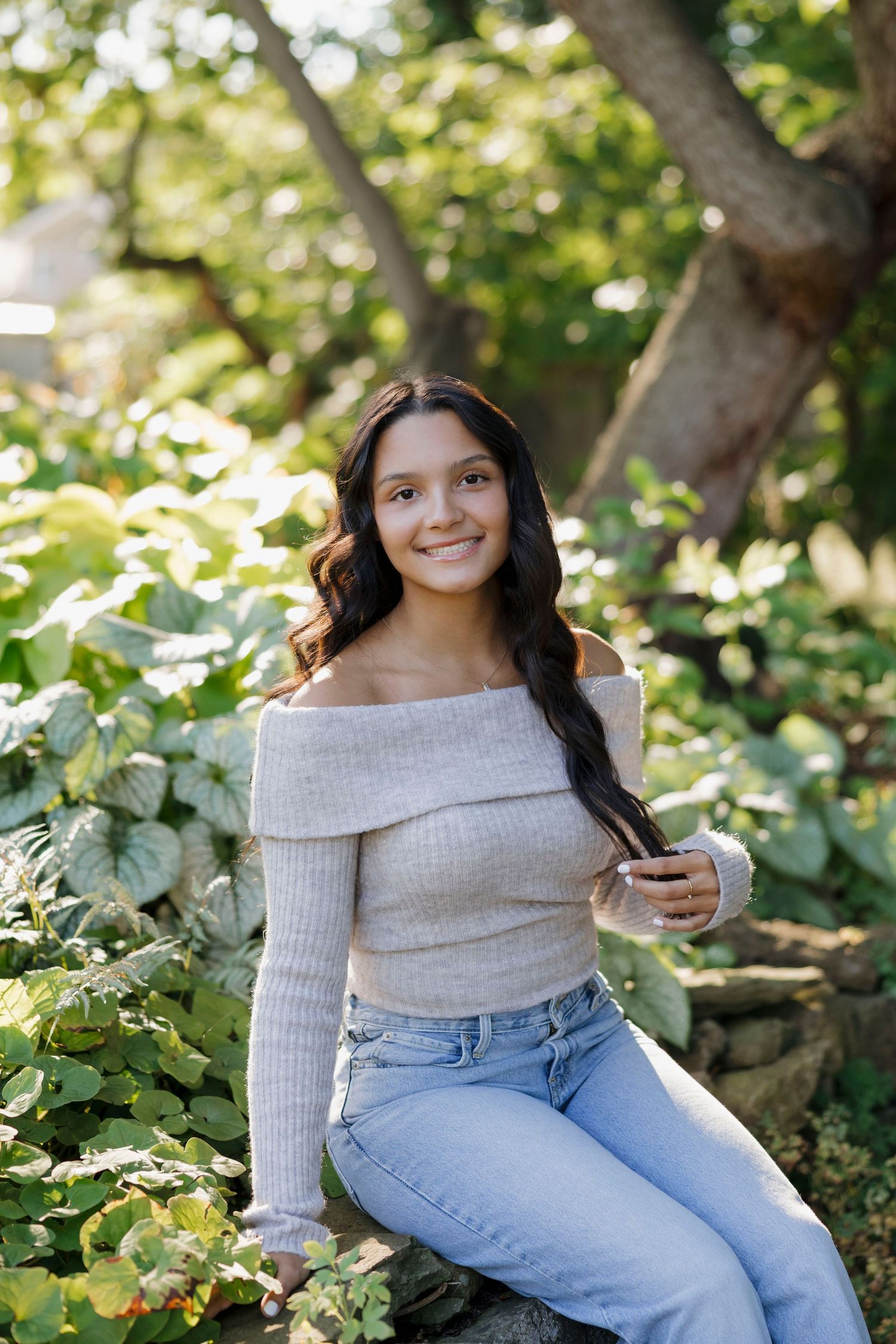A casual portrait session in a garden setting with light grey sweater and blue jeans at Saras Garden for Rochester, NY Senior portaits.