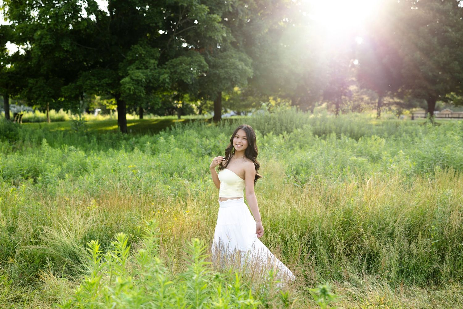 Outdoor portrait session in a field with tall grass and natural sunlight at Tinker Nature Center for Rochester NY senior portaits.