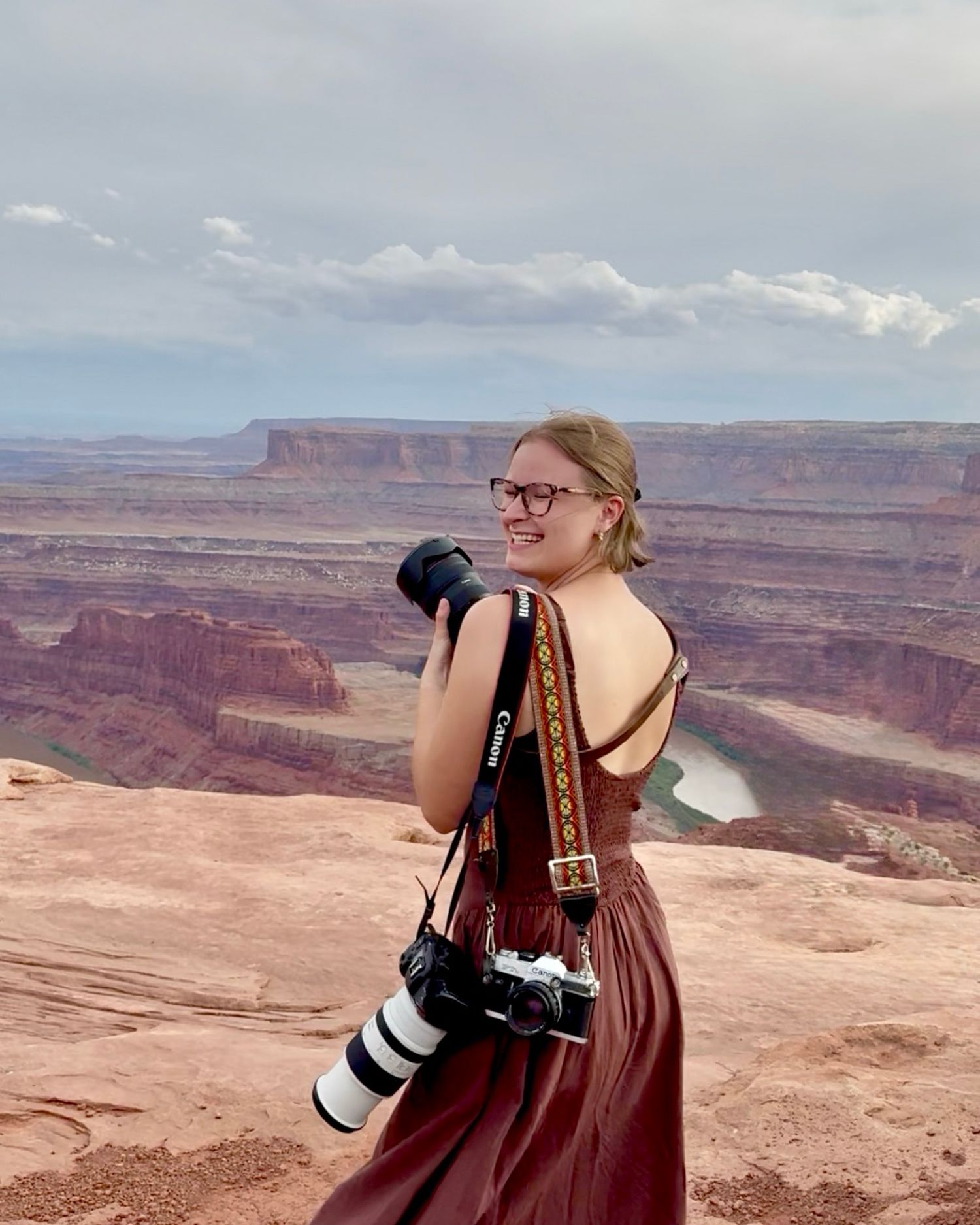 Photographer with camera captures scenic desert canyon views at Dead Horse State Park.