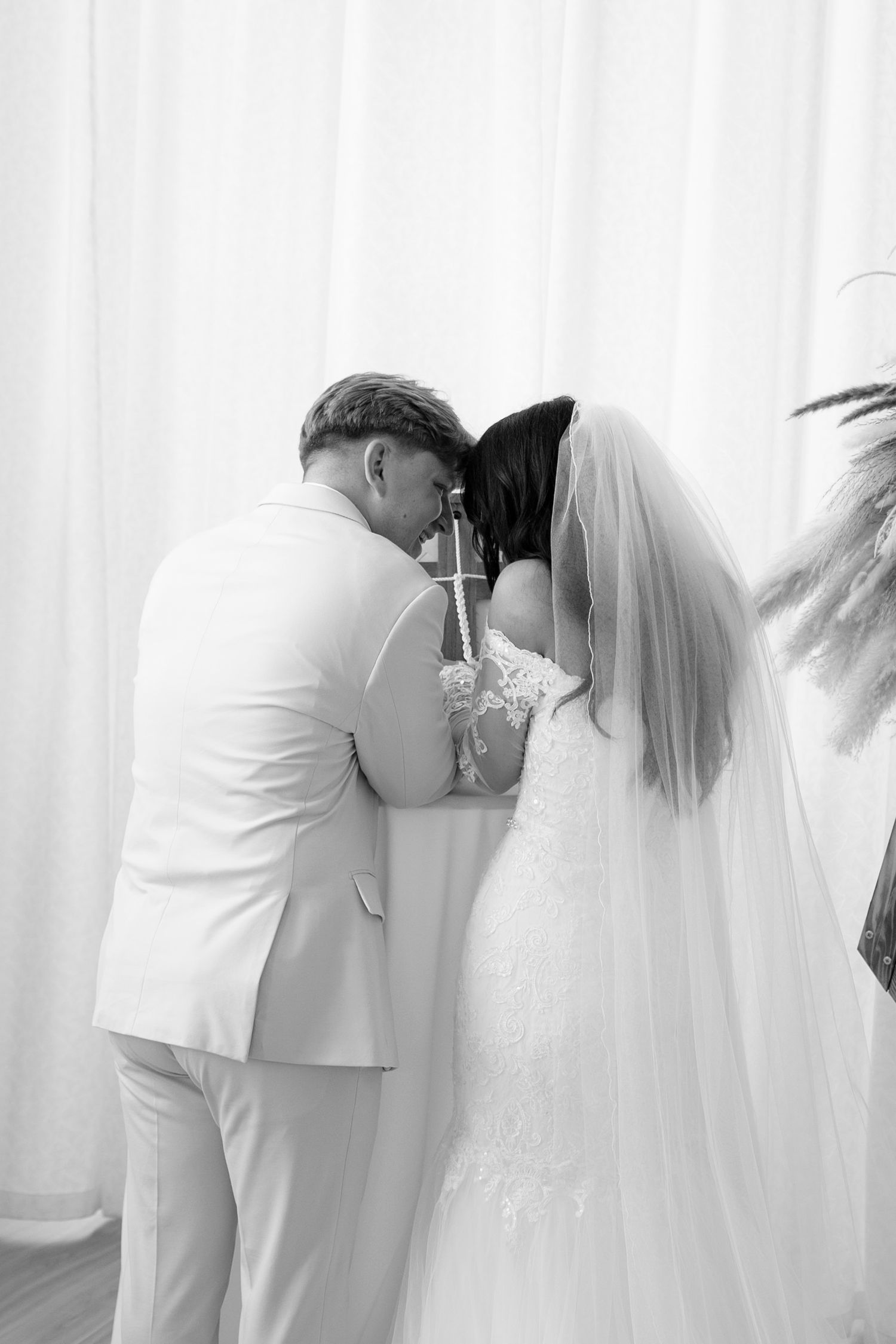 Intimate black and white wedding moment with flowing veil and white attire during ceremony at Arbor at the Port, Rochester, NY.