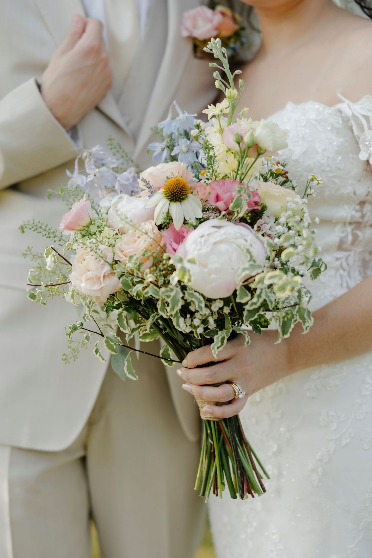 A delicate pastel bridal bouquet featuring white peonies, pink roses, and wildflowers with flowing greenery at Kin Loch Wedding.