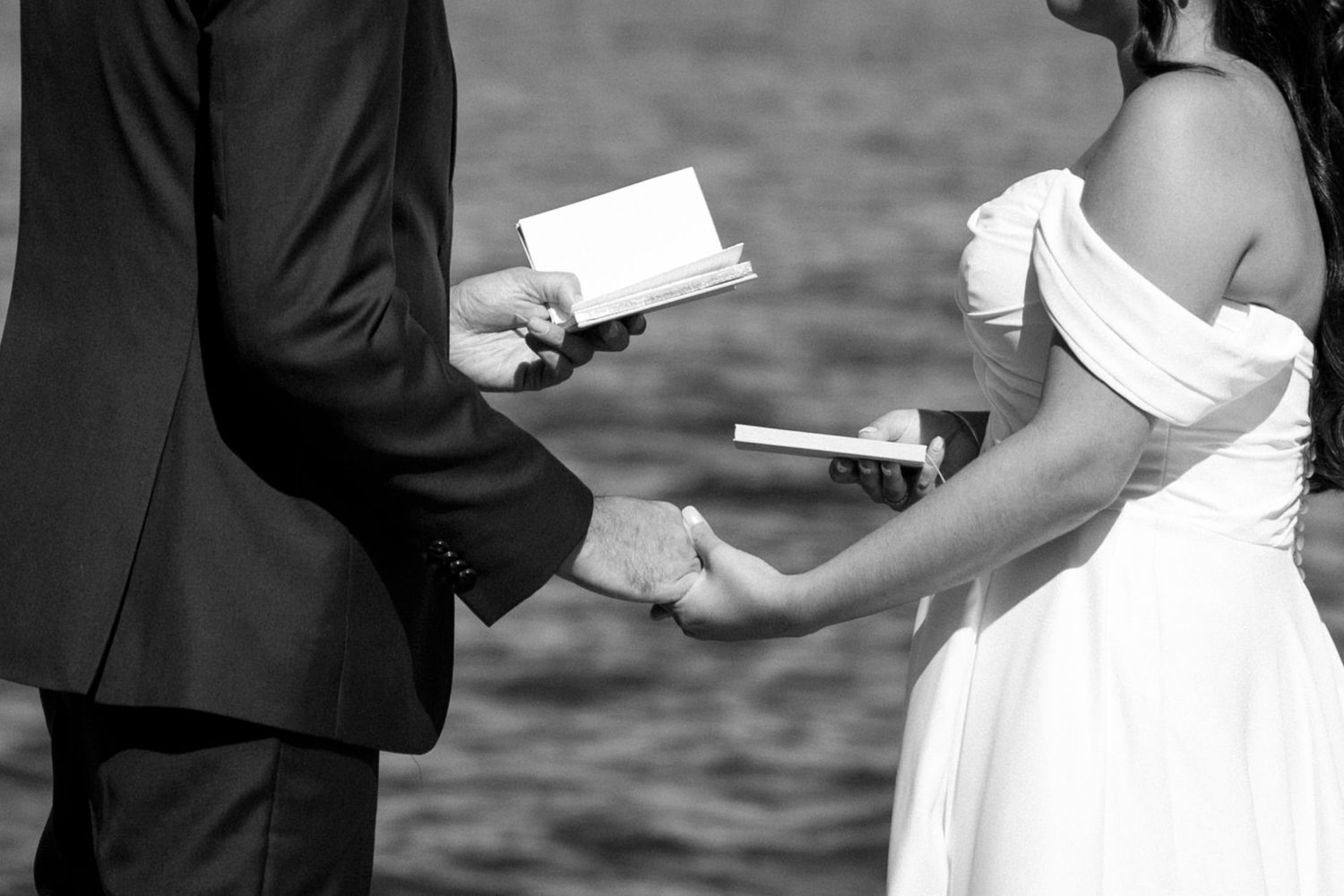 Black and white photo of couple exchanges vows during their lakeside wedding ceremony in Cayuga, Finger Lakes, New York wedding.