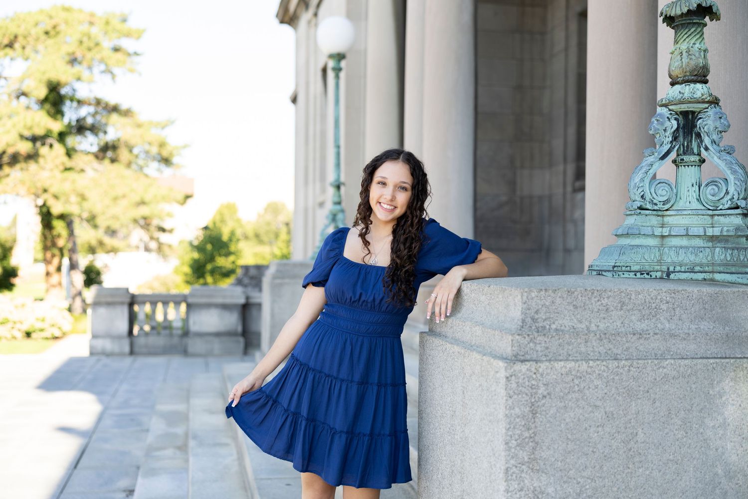 A photo session featuring a blue dress against classic stone columns and architecture at Memorial Art gallery for Rochester NY senior photos