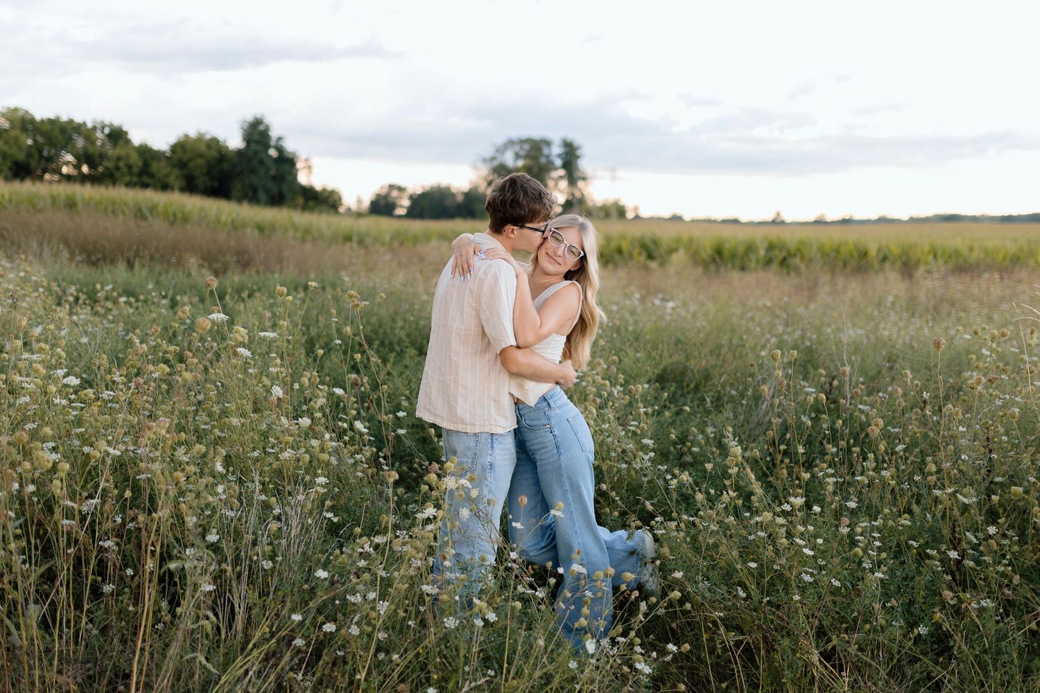 Couple walking through a wildflower field during golden hour.
