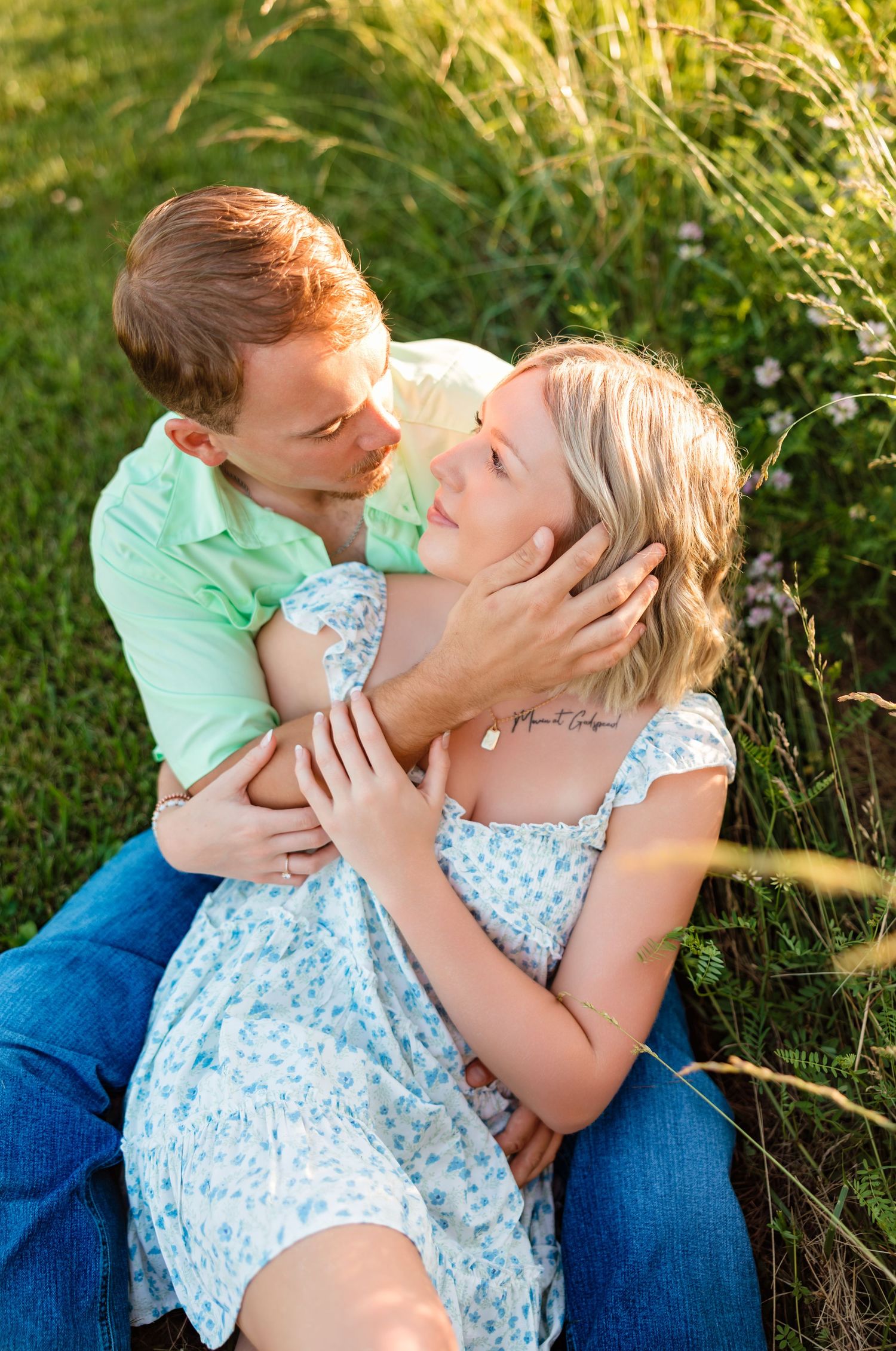 Intimate couple's portrait session in tall grass during golden hour.