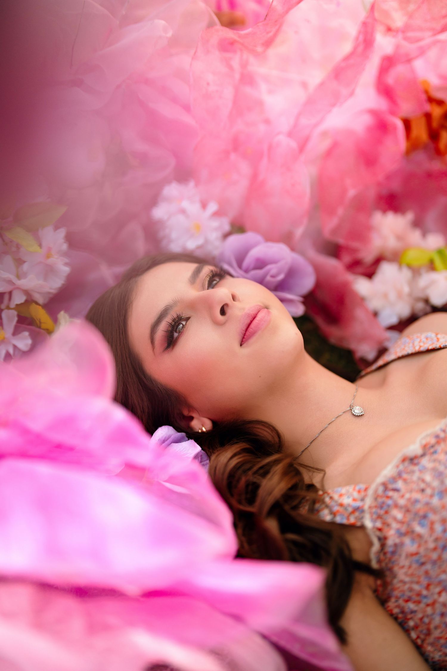 A dreamy portrait with pink cherry blossoms and floral decorations creating a romantic spring atmosphere.