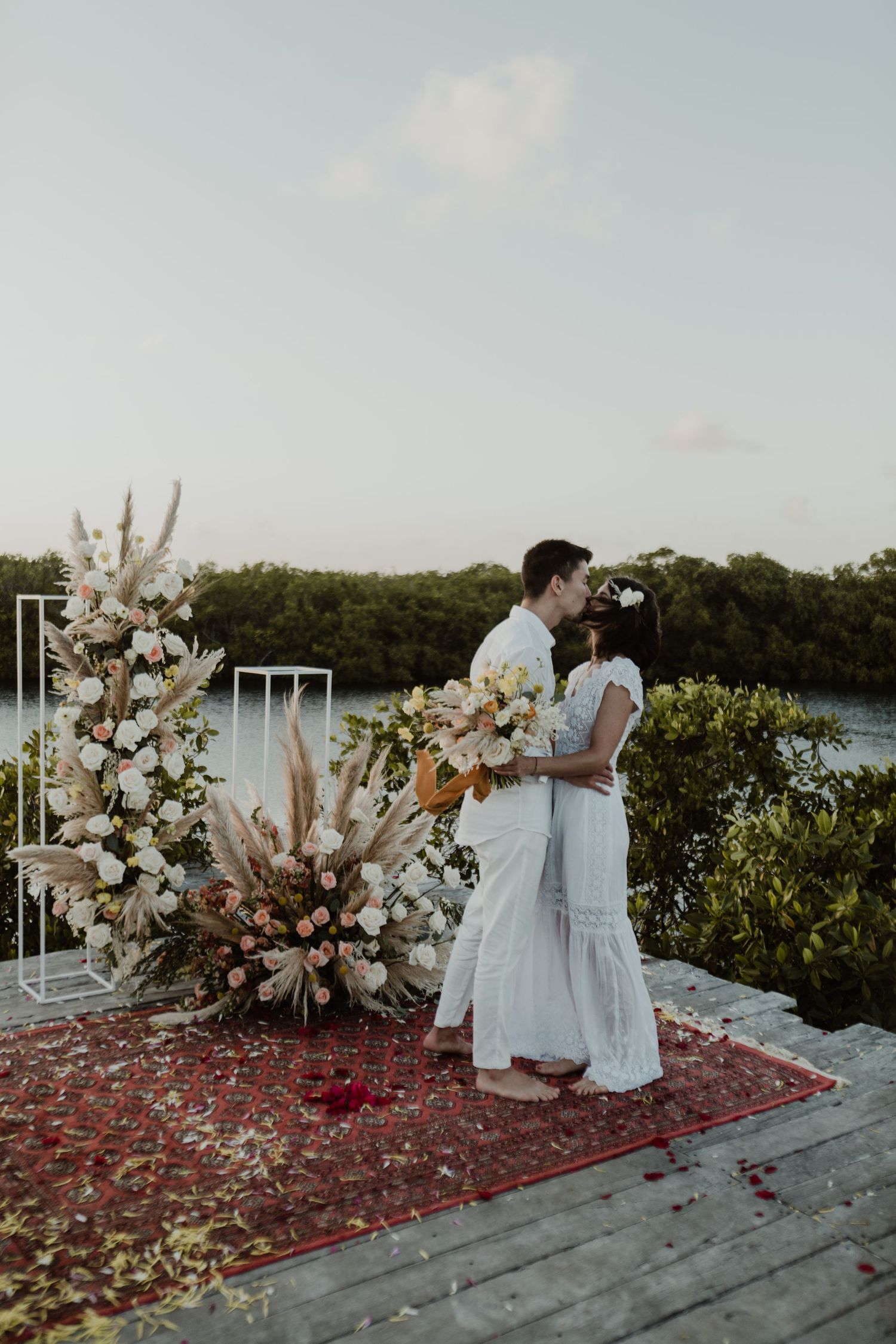 Bride and groom celebrating at altar with pampas during intimate elopement in Tulum Riviera Maya photographer.