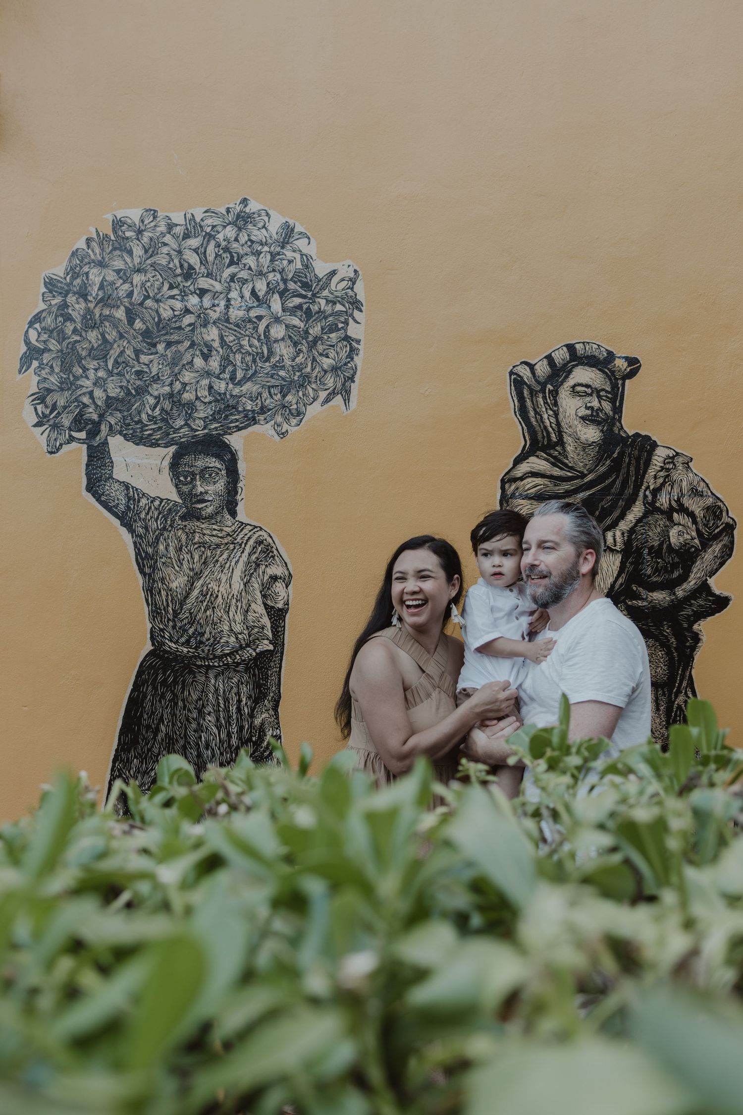 Family portrait by colorful Mexican mural at La Zebra Hotel, Tulum destination family photoshoot.