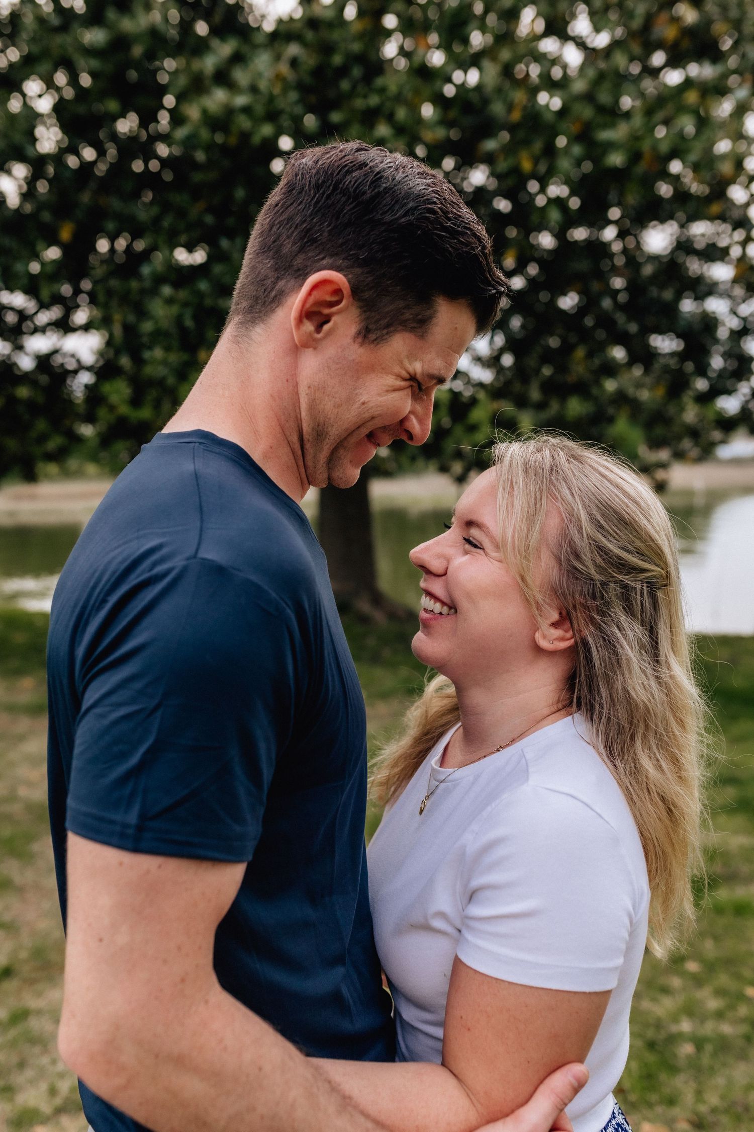 a couple hugging and laughing together in their backyard in chesapeake, virginia