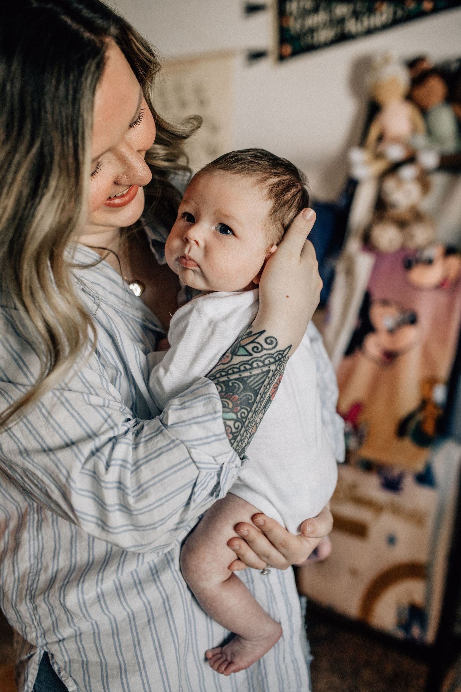 tattooed mom holding baby in her arms in her home in virginia beach, day in the life photography