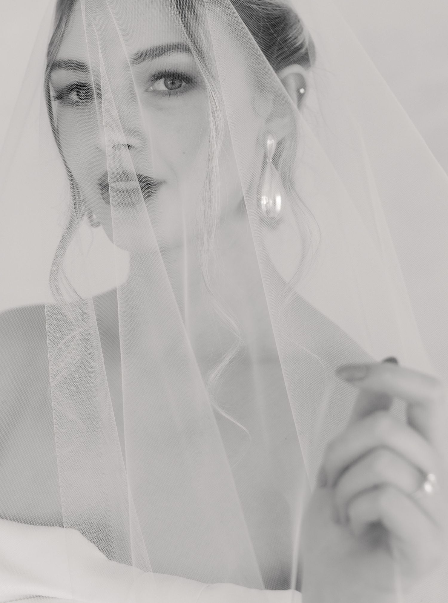 A series of black and white bridal portraits showing a veiled figure in soft, ethereal lighting.
