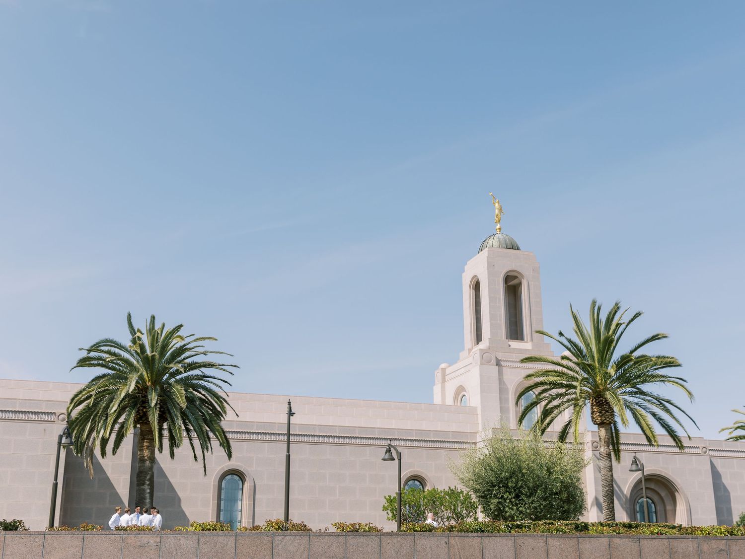 White church building with palm trees and blue sky in Newport Beach, California.