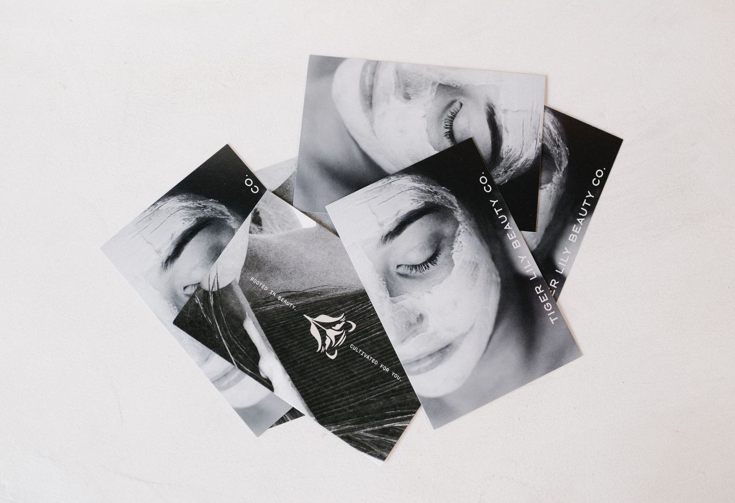 Black and white photo cards featuring close-up portraits of a woman's face scattered on a white surface.