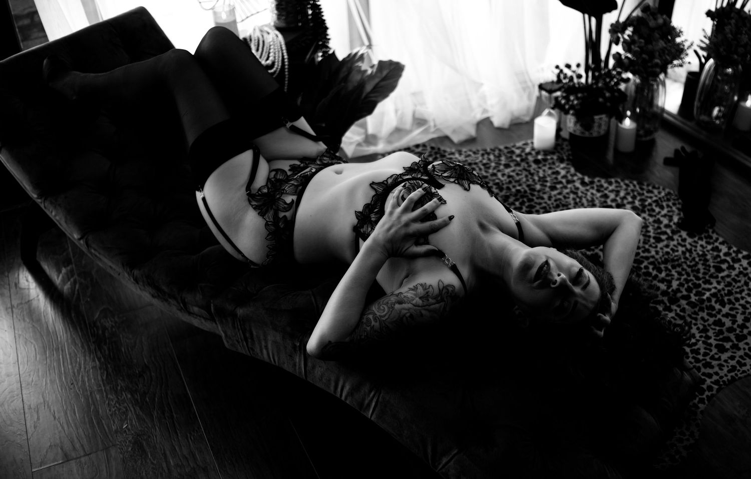 Dark and moody boudoir photo capturing a sensual, confident pose with luxury styling. Black lingerie, moody lighting. Elegant bridal boudoir