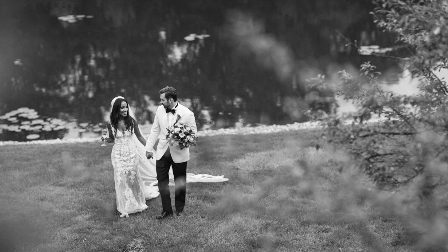 Black and white photo of couple walking through misty landscape.