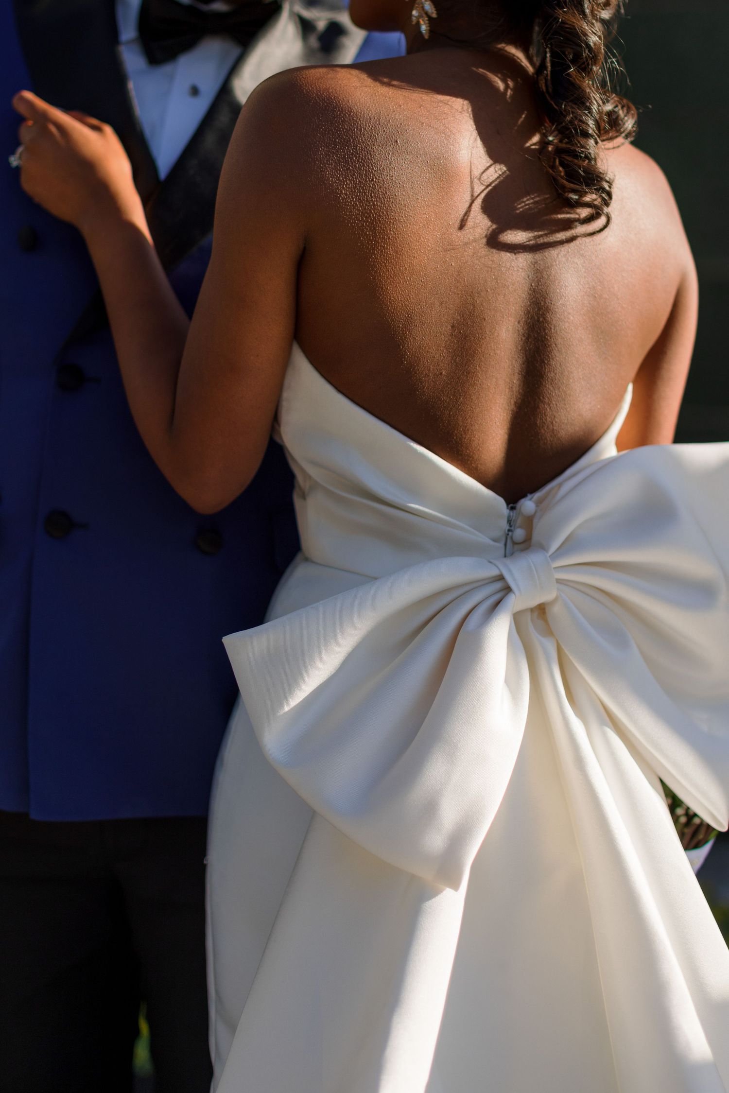 Elegant white wedding dress with dramatic oversized bow detail on the back.