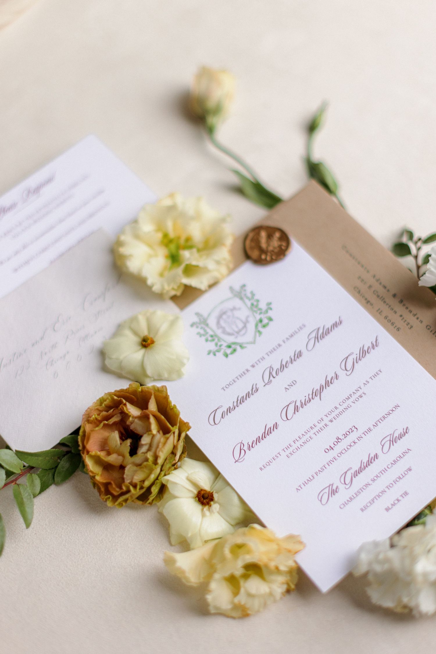 Wedding invitation with delicate floral design surrounded by cream and yellow flowers.