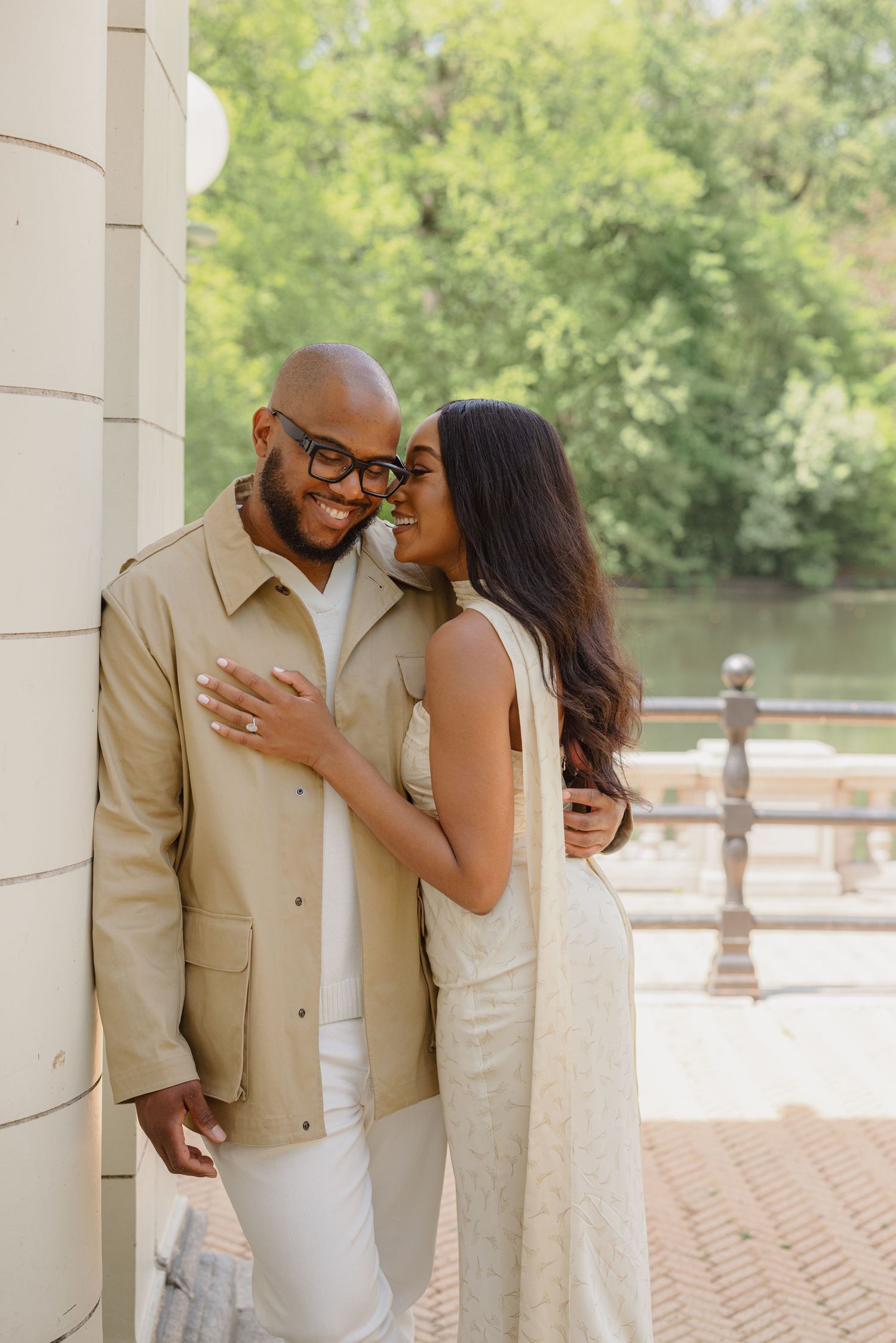 A romantic couple shares intimate moments in a series of photos taken under outdoor columns near a park.