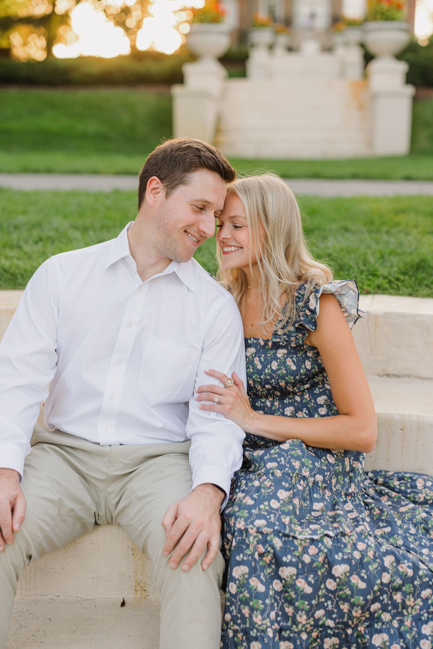 A couple shares an intimate moment while sitting together outdoors during golden hour.