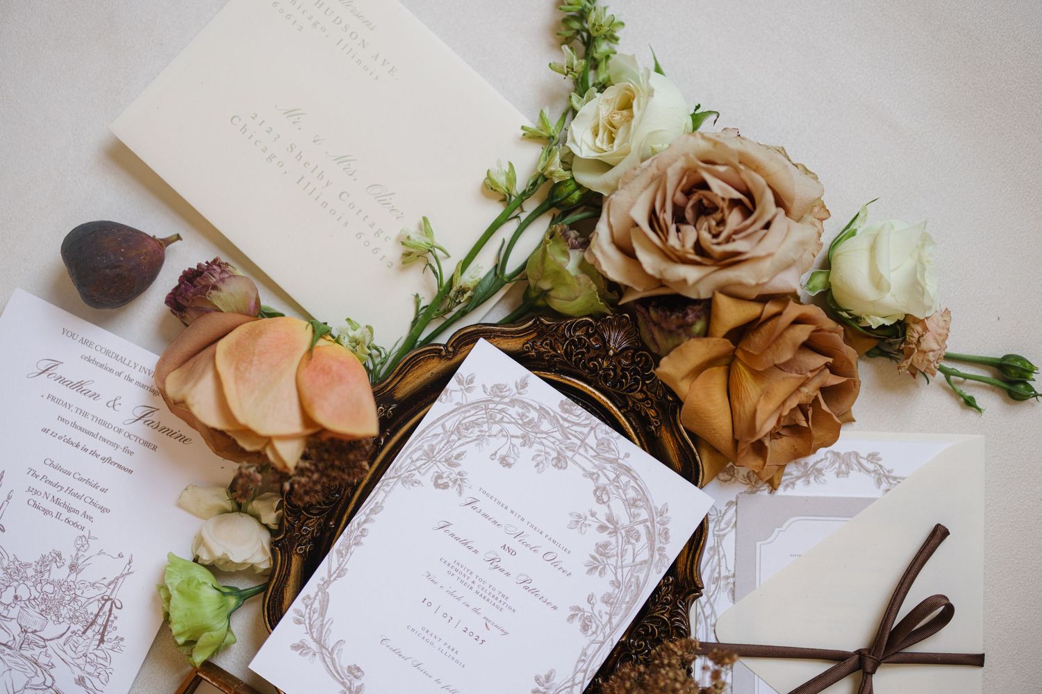 Elegant wedding invitation suite with dried flowers, brown ribbons, and handwritten calligraphy on white paper.