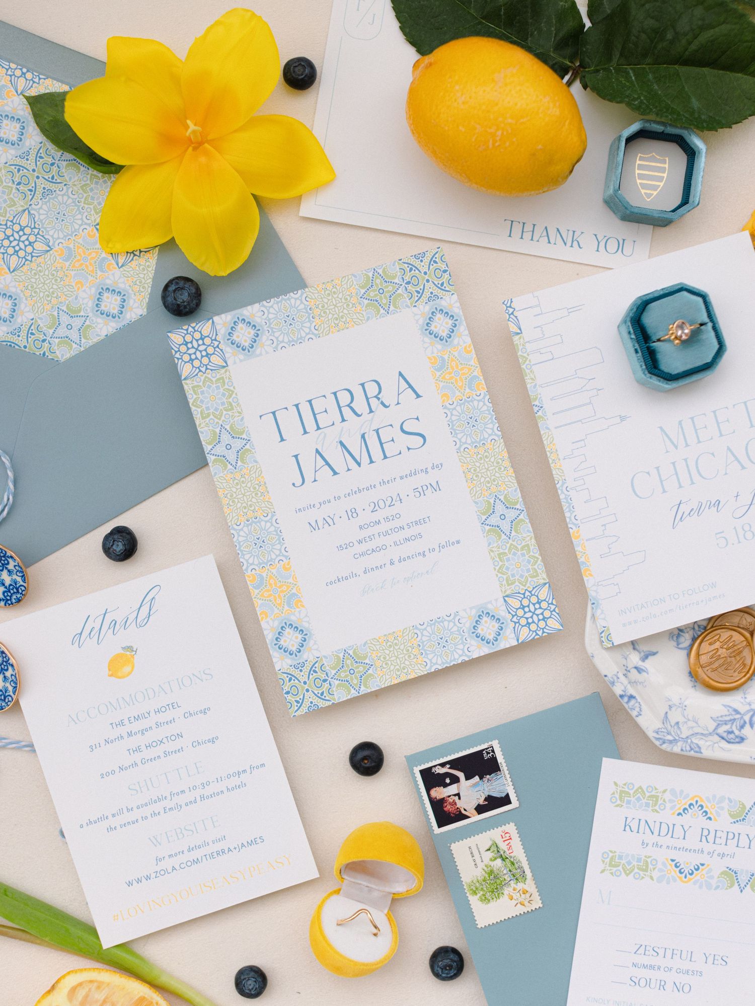 Yellow and blue wedding stationery flatlay with lemons and floral details.