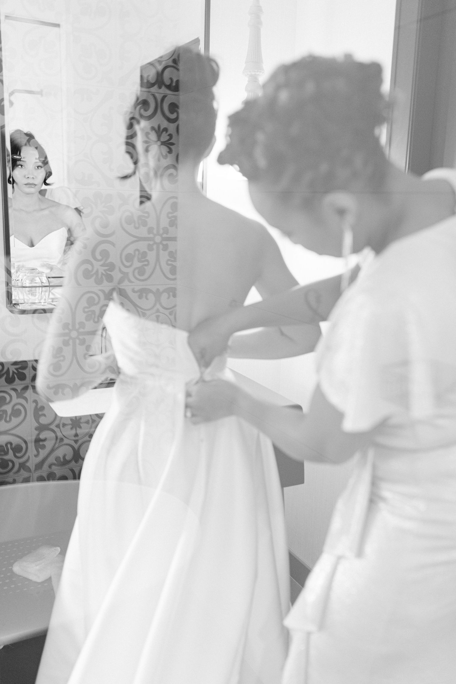 Black and white image showing final wedding dress adjustments being made.