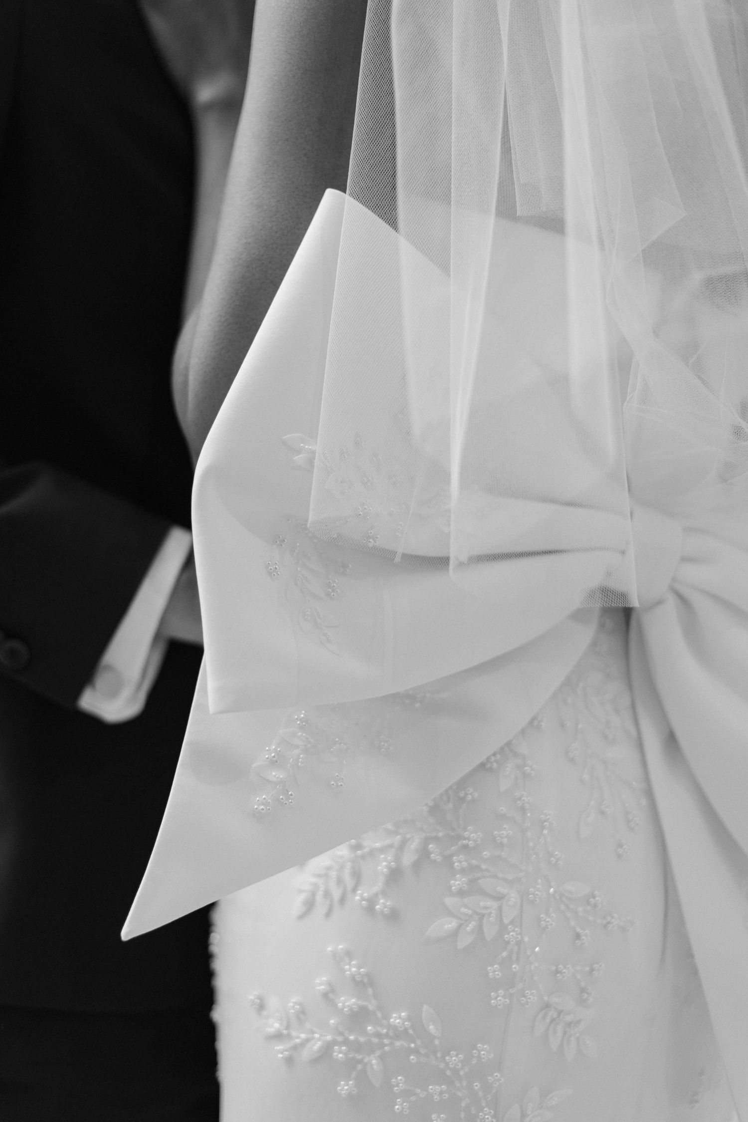 Detailed black and white photo of wedding dress veil and lace embroidery.