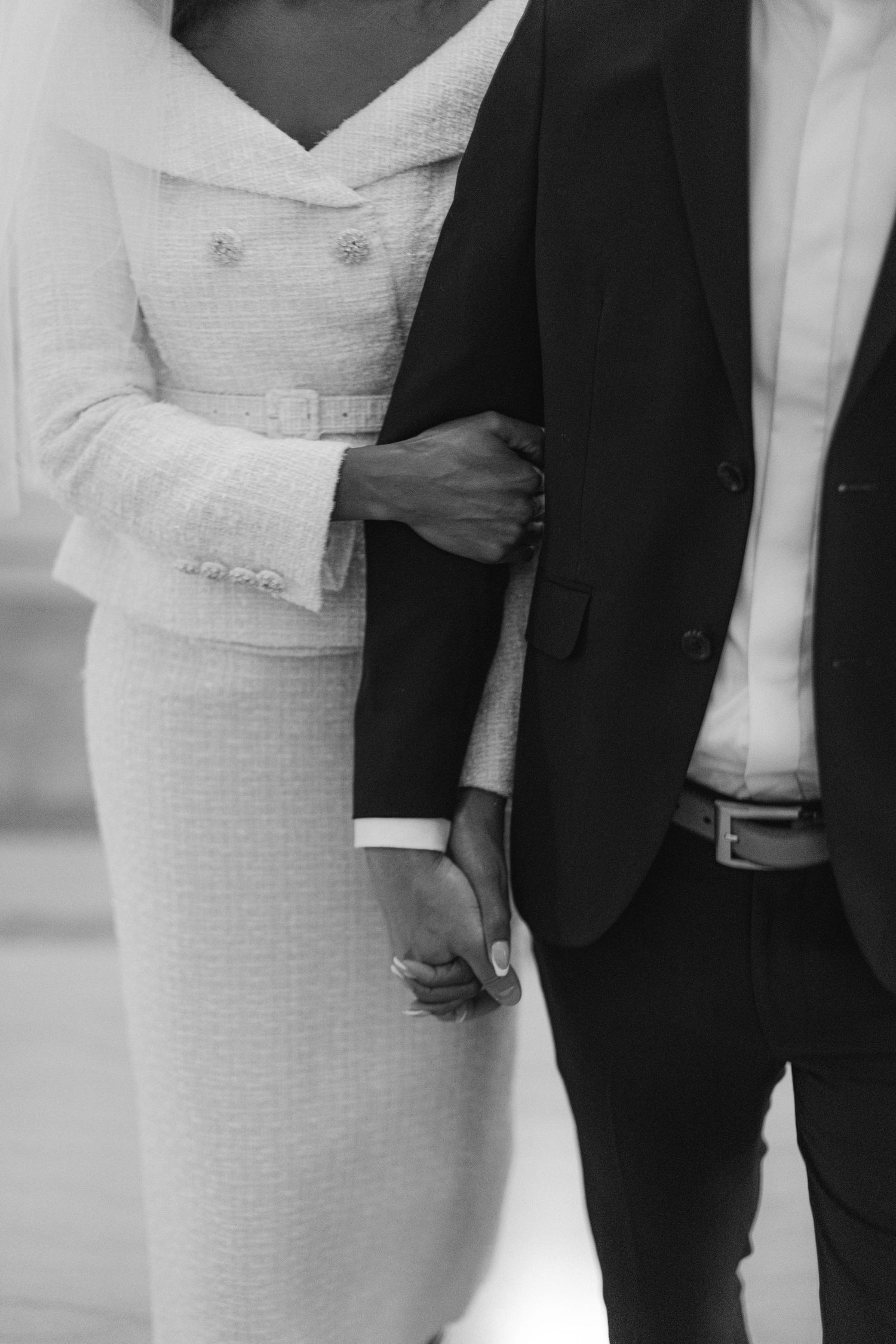 Close-up black and white photo of formal wedding attire showing dress and suit details.